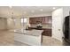Bright kitchen featuring dark wood cabinets, granite countertops, stainless steel appliances, and a large island at 10065 E Tiger Lily Ave, Mesa, AZ 85212