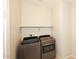 Bright laundry room with modern stainless steel washer and dryer and white walls at 10065 E Tiger Lily Ave, Mesa, AZ 85212