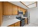 Well-equipped kitchen with wood cabinets, stainless steel appliances, and quartz countertops at 1021 S Greenfield Rd # 1077, Mesa, AZ 85206