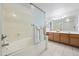 Bright bathroom featuring a tub with a glass enclosure, double sinks and tile flooring at 10410 N Cave Creek Rd # 1100, Phoenix, AZ 85020