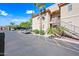 Condo exterior featuring tan stucco, desert landscaping, parking, and entry stairs at 10410 N Cave Creek Rd # 1100, Phoenix, AZ 85020