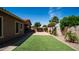Backyard with lush green artificial turf and a paved patio area surrounded by plants and trees at 1104 E Tekoa Ave, Gilbert, AZ 85298