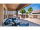 Backyard patio with a plush sectional seating area, outdoor table and palm tree at 1104 E Tekoa Ave, Gilbert, AZ 85298