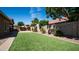 Expansive backyard with manicured artificial turf and mature trees and shrubs at 1104 E Tekoa Ave, Gilbert, AZ 85298