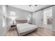 A calming bedroom featuring neutral tones, light wood floors, and a barn door leading to the ensuite bathroom at 1104 E Tekoa Ave, Gilbert, AZ 85298