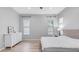 This bedroom features light wood floors, a dresser, and natural light from two windows with bright decor at 1104 E Tekoa Ave, Gilbert, AZ 85298