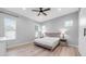 A bright bedroom features wood-look floors, a ceiling fan, and neutral decor, with ample natural light at 1104 E Tekoa Ave, Gilbert, AZ 85298