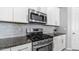 Close-up of stainless steel gas range, microwave, and granite countertops in kitchen at 1104 E Tekoa Ave, Gilbert, AZ 85298