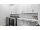 Laundry room with white cabinets, countertop, and stainless steel washer and dryer at 1104 E Tekoa Ave, Gilbert, AZ 85298
