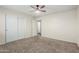 Carpeted bedroom with a ceiling fan and closet featuring sliding doors at 12376 W Hazelwood St, Avondale, AZ 85392