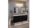 Elegant bathroom with a double vanity, framed mirrors, and modern lighting fixtures at 12950 W Cassia Trl, Peoria, AZ 85383