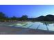 Large, well-lit community pool with lounge chairs and mountain views at twilight at 12950 W Cassia Trl, Peoria, AZ 85383