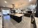 Open-concept kitchen featuring a large island with seating, dark cabinetry, and a seamless connection to the living area at 12950 W Cassia Trl, Peoria, AZ 85383