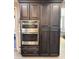 Contemporary kitchen boasts stainless steel double oven with custom cabinetry and hardware at 12950 W Cassia Trl, Peoria, AZ 85383