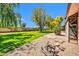 Landscaped backyard featuring a patio and a large tree at 14151 W Yosemite Dr, Sun City West, AZ 85375