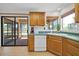 Charming kitchen features oak cabinets, green countertops, and a sliding glass door to the patio at 14151 W Yosemite Dr, Sun City West, AZ 85375