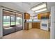 Bright kitchen with access to a screened patio, featuring wooden cabinets and white appliances at 14151 W Yosemite Dr, Sun City West, AZ 85375