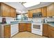 Traditional kitchen with wooden cabinetry, modern appliances, and bright overhead lighting at 14151 W Yosemite Dr, Sun City West, AZ 85375