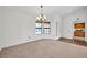 Open living room featuring neutral carpet, chandelier, vaulted ceilings and large windows, creating a bright and inviting space at 14151 W Yosemite Dr, Sun City West, AZ 85375