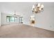 Bright living room features neutral carpet, vaulted ceilings, chandelier, ceiling fan, and plenty of windows at 14151 W Yosemite Dr, Sun City West, AZ 85375