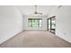 Spacious living room featuring neutral carpet, vaulted ceilings, ceiling fan, and a sliding glass door to the backyard at 14151 W Yosemite Dr, Sun City West, AZ 85375