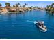 Aerial view of a serene lake community, showcasing a boat pulling a wakeboarder and the calm blue waters at 1539 W Laurel Ave, Gilbert, AZ 85233
