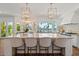 Bright and spacious kitchen island with seating, statement lighting, and views of the pool and backyard at 1539 W Laurel Ave, Gilbert, AZ 85233