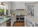 Gourmet kitchen featuring marble countertops, stainless steel appliances, and designer tile backsplash at 1539 W Laurel Ave, Gilbert, AZ 85233