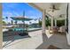 Spacious covered patio with lounge chairs and dining set overlooking a pool and waterfront at 1539 W Laurel Ave, Gilbert, AZ 85233