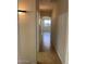 Hallway features beige walls and tile floors and a window at the end of the hall at 15461 W Jefferson St, Goodyear, AZ 85338