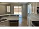 Bright open-concept kitchen with stainless appliances, quartz counters, tile flooring, and backyard access at 15461 W Jefferson St, Goodyear, AZ 85338