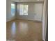 Bright and airy living room featuring tile floors, neutral paint, and large windows at 15461 W Jefferson St, Goodyear, AZ 85338