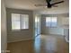 Open living room area featuring tile floors, a modern ceiling fan, large windows, and sliding glass doors at 15461 W Jefferson St, Goodyear, AZ 85338