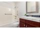 Bathroom featuring a shower-tub combo, grab bars, vanity, and wooden cabinet at 1550 S Chaparral Blvd, Gilbert, AZ 85296