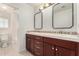 A lovely bathroom with double sinks, a wooden cabinet, and a shower-tub combo is featured at 1550 S Chaparral Blvd, Gilbert, AZ 85296