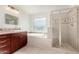 Bright bathroom featuring a soaking tub, glass shower, vanity, and natural light from frosted window at 1550 S Chaparral Blvd, Gilbert, AZ 85296