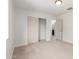 Bright bedroom with neutral carpet and trim, features a closet and doorway at 1550 S Chaparral Blvd, Gilbert, AZ 85296