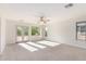 Bright bedroom with a ceiling fan, access to balcony, and windows offering natural light and neighborhood views at 1550 S Chaparral Blvd, Gilbert, AZ 85296