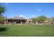 Expansive backyard featuring lush green lawn, covered patios, and views of the mountains at 16420 N Thompson Peak Pkwy # 2020, Scottsdale, AZ 85260