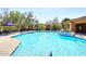 A community pool with lounge chairs, umbrellas, and mature shade trees at 16420 N Thompson Peak Pkwy # 2020, Scottsdale, AZ 85260