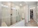 Clean, modern shower area and walk in closet in bathroom, with tiled walls and glass door at 16946 W Vernon Ave, Goodyear, AZ 85395