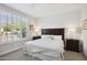Bright bedroom featuring plantation shutters, a plush bed, and dark wood furniture at 16946 W Vernon Ave, Goodyear, AZ 85395