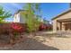Scenic backyard with desert landscaping, gravel, blooming plants, artificial grass, and a covered patio view at 17736 W Cassia Way, Goodyear, AZ 85338