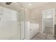 Luxurious bathroom featuring a glass-enclosed shower and a separate bathtub at 17736 W Cassia Way, Goodyear, AZ 85338