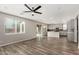 Open concept living area with modern light grey walls and hardwood floors, flowing into a bright kitchen at 17736 W Cassia Way, Goodyear, AZ 85338