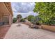 Scenic view of the backyard featuring mature trees, manicured landscaping, and a cozy seating area at 17951 W Sammy Way, Surprise, AZ 85374