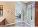 Well-lit bathroom featuring a glass door shower, neutral color palette and mosaic-style flooring at 17951 W Sammy Way, Surprise, AZ 85374