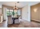 Comfortable dining area featuring ceramic tile flooring, a modern light fixture, and backyard access at 17951 W Sammy Way, Surprise, AZ 85374