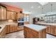 Modern kitchen with tile floors and countertops, wooden cabinets, and stainless-steel appliances at 17951 W Sammy Way, Surprise, AZ 85374