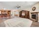 Spacious living room with a cozy fireplace, tile flooring, and a ceiling fan at 17951 W Sammy Way, Surprise, AZ 85374